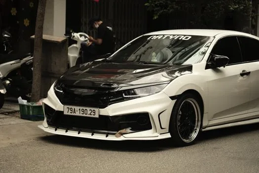 A sleek, custom-modified white sports car parked on an urban street. Perfect for enthusiasts.
